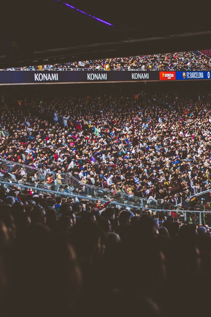 Large energetic crowd gathering in a football stadium, showcasing excitement and fan enthusiasm.